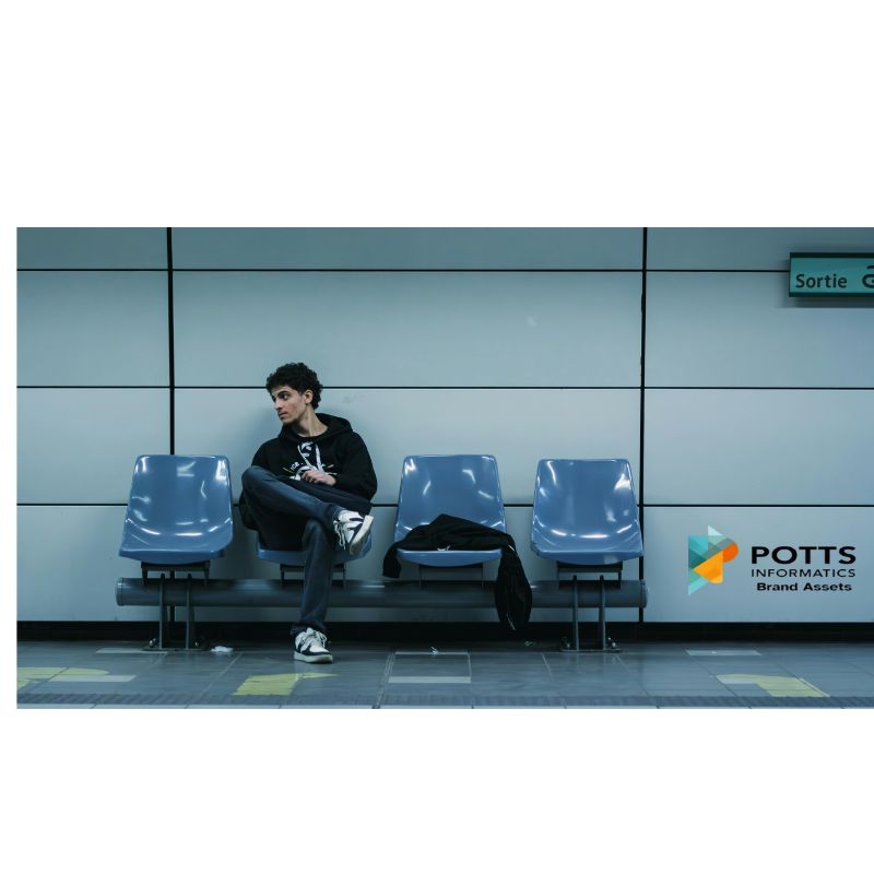 Person sitting on blue chairs in waiting area looking at phone symbolizing making others wait