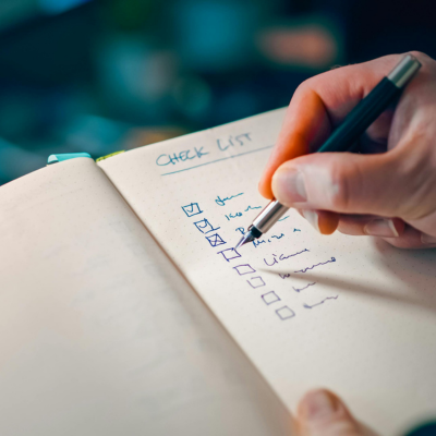 writing in notebook with checklist for task management