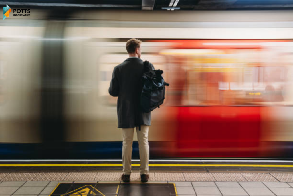 A man with a backpack stands on a subway platform as a train blurs past him in a streak of motion.